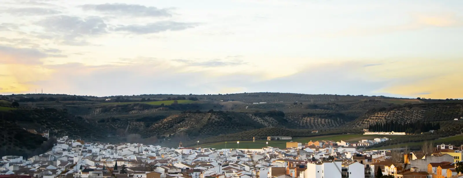 Un pueblo blanco al atardecer entre colinas